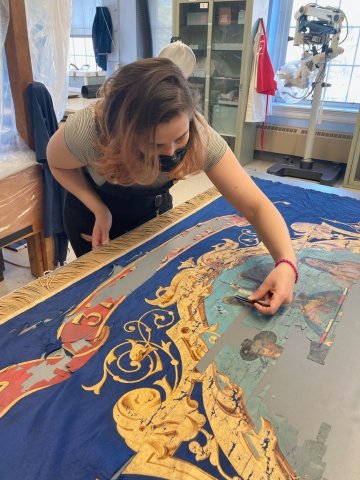 person restoring regimental flag